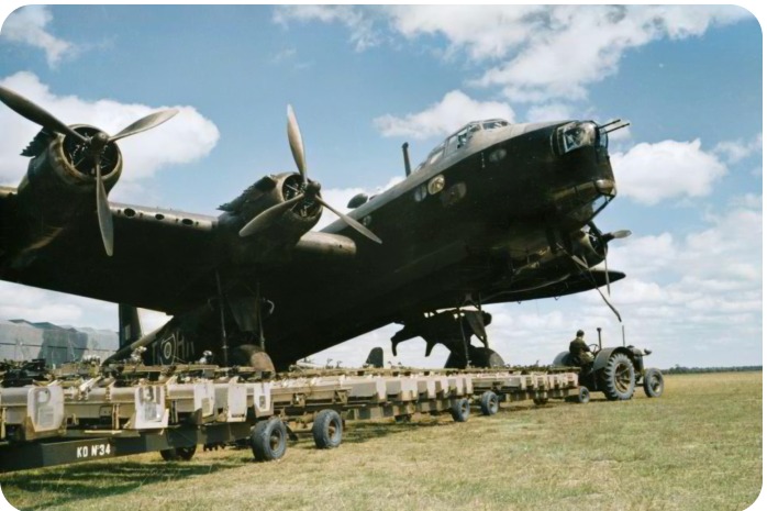WW2 heavy bomber being loaded on a grass airfield